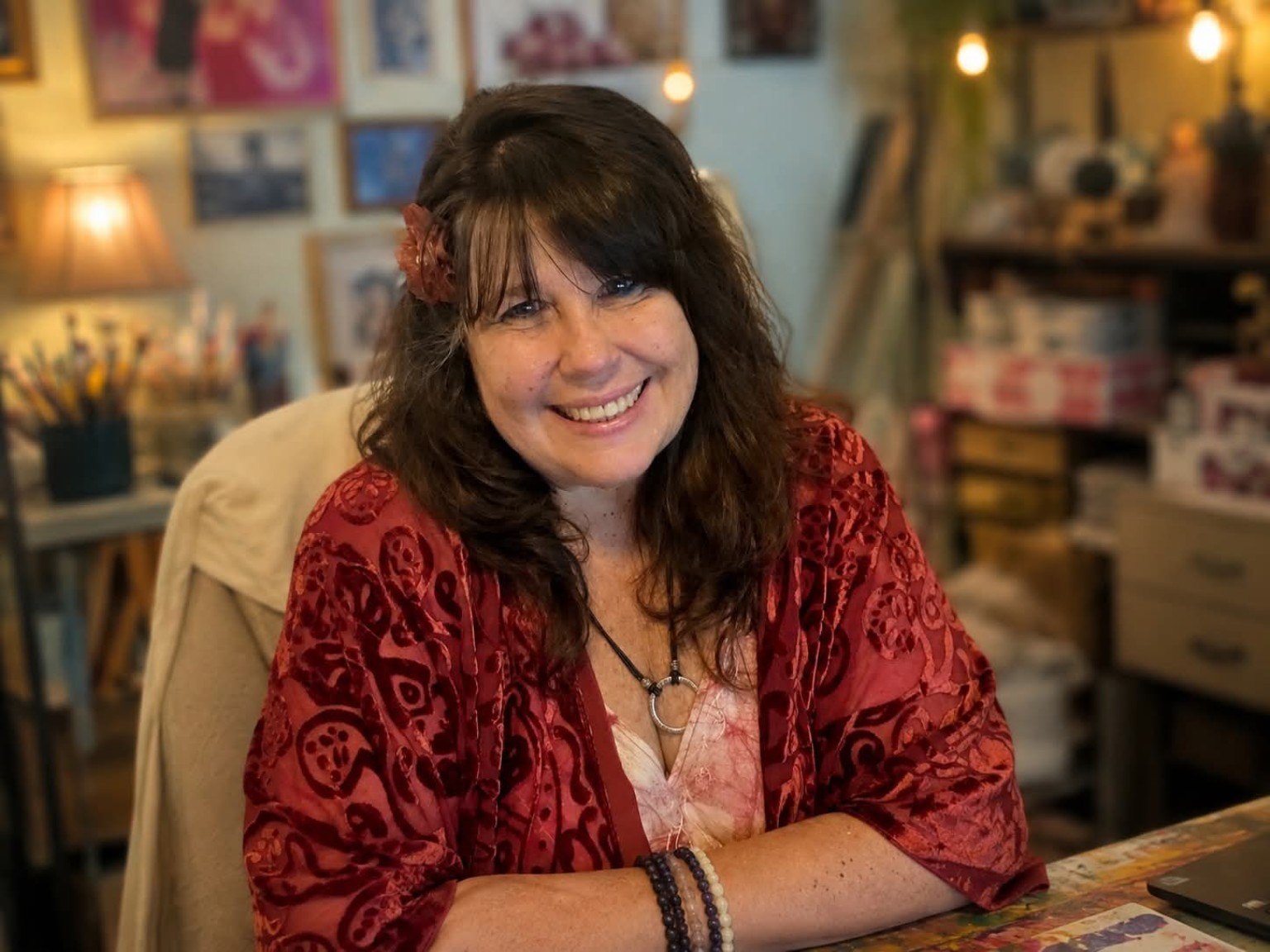 Michelle Bryant Griffin smiling at her desk in her art studio